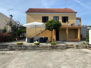 a house with an umbrella in front of it at Casa do Avô Grande in Esposende