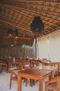 a group of wooden tables and chairs in a restaurant at Astral Tulum in Tulum