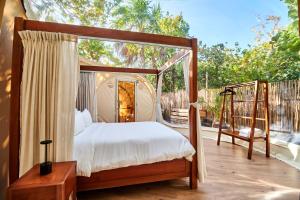 a bedroom with a canopy bed and a balcony at Astral Tulum in Tulum