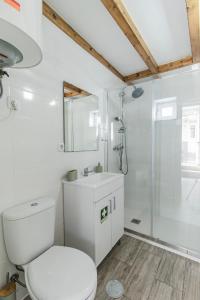 y baño blanco con aseo y ducha. en Casa das Virtudes - Estadia no coração do Porto, Lapa en Oporto