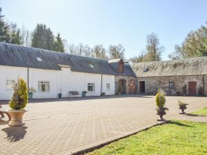 a large white building with a brick courtyard at Oak Cottage - Uk43458 in Killin