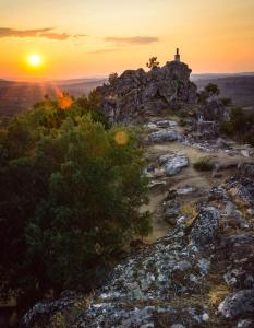 a church on top of a mountain at sunset at Villa Tauria- Casa de campo em aldeia medieval in Sabugal