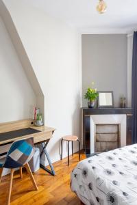 a bedroom with a desk and a bed and a table at Chambre - Marceau in Courbevoie