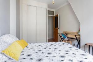 a bedroom with a bed with a yellow pillow on it at Chambre - Marceau in Courbevoie