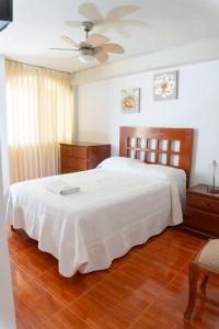 a bedroom with a large bed with a white blanket at Hospedaje Claudia in Ica