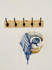 een houten handdoekenrek met een mand aan de muur bij Caparica Rooftop Beach Apartment in Costa da Caparica