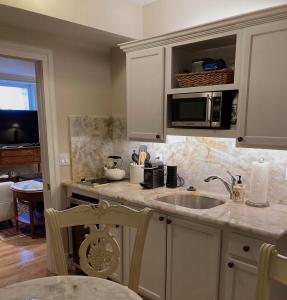 a kitchen with a sink and a microwave at Pineapple House, Spacious 1st Floor Apartment! City Center! 96 Walk Score! FREE parking! in Denver