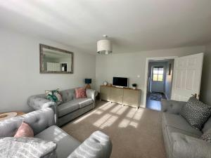 Sala de estar con 2 sofás y TV en Denburn Cottage, East Neuk of Fife, en Colinsburgh