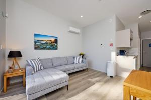 a living room with a couch and a table at Shearwater Apartments in Kaikoura