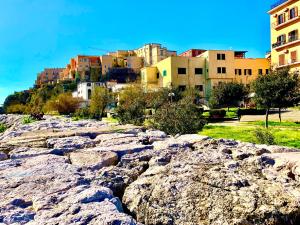 a group of buildings on a hill with rocks at Artis Mare in Pozzuoli