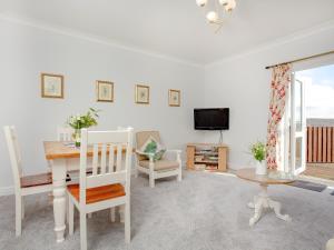 a living room with a table and a television at Valley View - Uk43268 in Luppitt