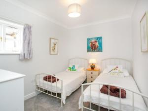 two beds in a room with white walls at Valley View - Uk43268 in Luppitt