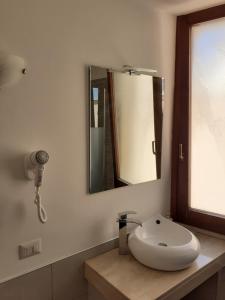 a bathroom with a white sink and a mirror at Sweet Suite Margherita B&B in Margherita di Savoia