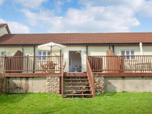 a house with a wooden deck with a staircase at Valley View - Uk43268 in Luppitt