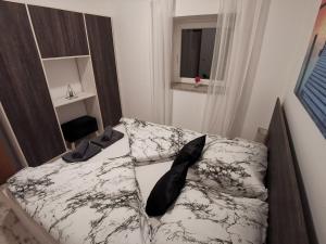 a bed with black and white sheets and a window at Haus Cataleya in Umag