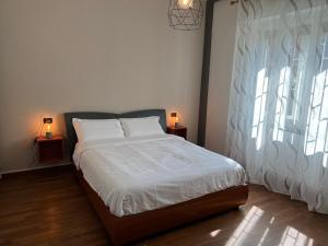 a bedroom with a bed with two lamps on two tables at Relax Segrate in Segrate