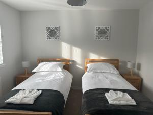 due letti uno accanto all'altro in una camera da letto di Denburn Cottage, East Neuk of Fife a Colinsburgh