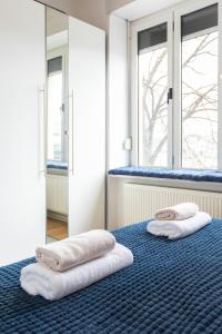 2 handdoeken op een bed in een kamer met ramen bij Cibona Station Apartments in Zagreb