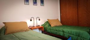 Habitación con 2 camas y mesa con lámparas. en Departamento HOSPITAL PRIVADO - MATERNIDAD - QUALITY - CORDOBA en Córdoba