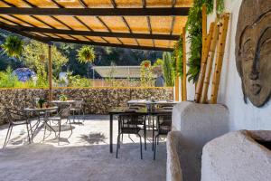 patio ze stołami i krzesłami pod drewnianą pergolą w obiekcie Amazing Cyprus Glamping Domes - Glamping Cyprus w Pafos