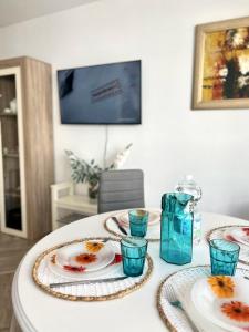 Biały stół z tablicami i niebieskimi okularami w obiekcie Apartamento estilo árabe en el centro De San Pedro de Alcántara - Toledo 1b w Marbelli