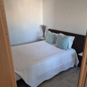 1 dormitorio con 1 cama con sábanas blancas y almohadas azules en Sunsetview, en Portimão