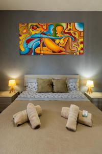 - une chambre avec un lit orné d'une peinture murale dans l'établissement Villa MiraMar Exclusive Home Palermo Airport, à Carini