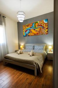 - une chambre avec un lit orné d'une peinture murale dans l'établissement Villa MiraMar Exclusive Home Palermo Airport, à Carini