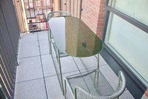 a table and a chair on a balcony at Apartment in the heart of london Greenford in Perivale