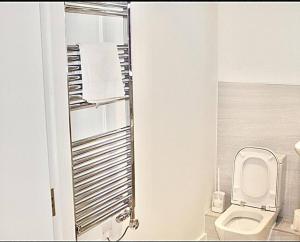 a white bathroom with a toilet and towels at Apartment in the heart of london Greenford in Perivale