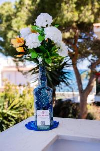 une bouteille bleue avec des fleurs sur une table dans l'établissement Villa MiraMar Exclusive Home Palermo Airport, à Carini