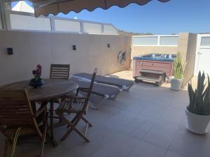 a patio with a table and chairs and a grill at Bungalow el Valle in Puerto Rico with Jacuzzi in Puerto Rico de Gran Canaria