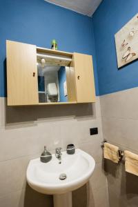 La salle de bains est pourvue d'un lavabo blanc et d'un miroir. dans l'établissement Villa MiraMar Exclusive Home Palermo Airport, à Carini