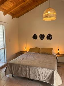 Un dormitorio con una cama grande y una lámpara de araña. en Luminoso y amplio departamento en Mendoza