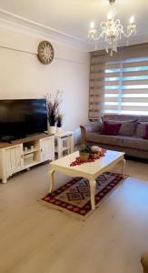 uma sala de estar com uma televisão e uma mesa de centro em Bursa Park em Çekirge