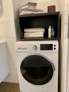 una lavadora blanca en una cocina con toallas en Helles Apartment über den Dächern Rostocks en Rostock