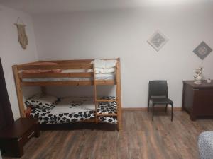 a room with two bunk beds and a chair at Petite maison lirenolles in Liernolles