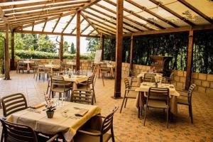 a restaurant with tables and chairs and a grill at Hotel Villa Paradiso in Riparbella
