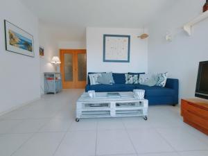 un soggiorno con divano blu e TV di Precioso apartamento con piscina en Tamariu a Tamariu
