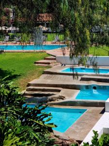 a row of three swimming pools in a park at Hotel Hacienda Taboada (Aguas Termales) in San Miguel de Allende