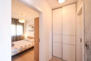 sypialnia z łóżkiem i przesuwnymi szklanymi drzwiami w obiekcie COCO w mieście Pirovac