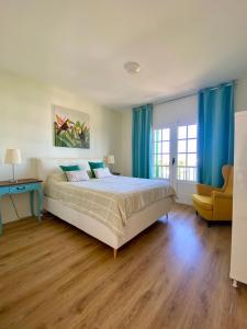 una camera con un grande letto e tende blu di Apartamento OM con piscina y vistas al mar a Costa Teguise