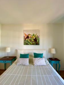 una camera da letto con un letto con due tavoli e un quadro di Apartamento OM con piscina y vistas al mar a Costa Teguise