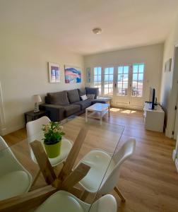 un soggiorno con divano e tavolo di Apartamento OM con piscina y vistas al mar a Costa Teguise