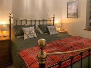 a bedroom with a large bed with pillows at Mudhorse Cottage in Stolford