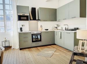 - une cuisine avec des appareils verts et blancs dans la chambre dans l'établissement L emeraude - Trouville, à Trouville-sur-Mer