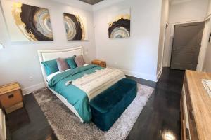 una camera da letto con un grande letto e un pouf blu di West End Modern Atlanta 3 Bedroom Bungalow ad Atlanta