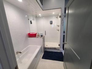 ein weißes Bad mit einer Badewanne und einem roten Waschbecken in der Unterkunft Atlanta Modern Beltline Bungalow in Atlanta + 21 Fotos