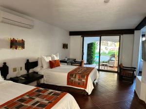 una camera d'albergo con due letti e un balcone di Hotel Hacienda Taboada (Aguas Termales) a San Miguel de Allende