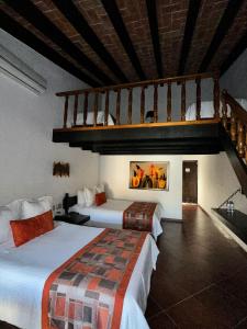 a hotel room with two beds and a staircase at Hotel Hacienda Taboada (Aguas Termales) in San Miguel de Allende